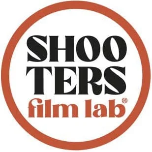 Logo reading 'SHOOTERS' in bold black above 'film lab' in orange, all within a rust-colored circular ring.