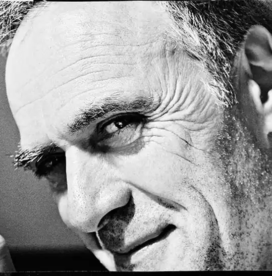 retrato salvador alsina - Revela't 2026 Close-up black-and-white portrait of a middle-aged man looking to the side, with pronounced wrinkles near the eyes and forehead.